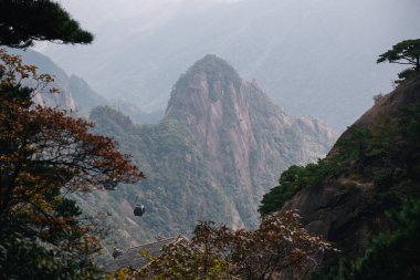 Huangshan, Çin 'de sisli bir günde sonbahar renkleri ile Sarı Dağ' a ulaşmak için teleferik görüntüsü.