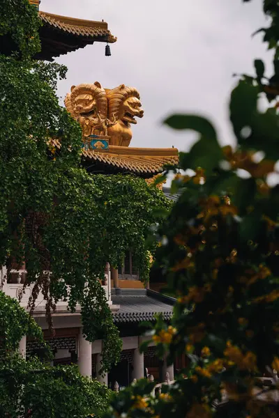 Şangay 'daki Jingan Tapınağı' nın ünlü altın aslan heykelinin görüntüsü şehrin merkezindeki tapınak kompleksinin ağaçlarının arasında.