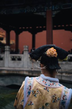 Yasak Şehir, Pekin, Çin 'in bahçesinde geleneksel kostümlü Çinli genç bir kadının arka görüntüsü.