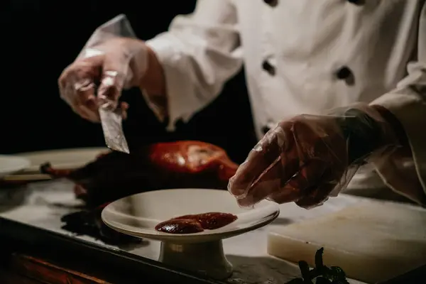 Pekin, Pekin 'deki lüks bir restoranda aşçı közlenmiş ördek pişirip servis ediyor. Bu İmparatorluk döneminden beri geleneksel bir yemektir; ördek derisi çıtır çıtır ve karakterize edilir..