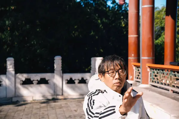 Pekin, Çin; 19 Ekim 2024: Çin İmparatorluk Yaz Sarayı 'nın tapınağında sabah yoga yapan kıdemli Çinli adam