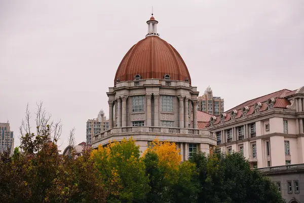 Çin 'deki sömürge döneminden kalma Tianjin nehir kıyısındaki tarihi binanın köşesinde ağaçlar ve sonbahar yaprağı renkleri var..