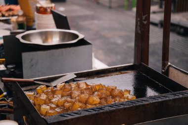 Çin 'in Pekin yakınlarındaki Tianjin' in ana caddesindeki Çin gıda pazarında kızartılmış tofu, yemek pişirme aletinin yanındaki metal tabakta sergileniyor.