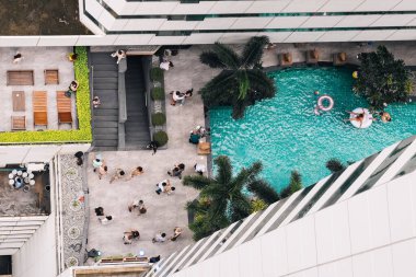 İnsanlar salsa yapıyor ve lüks otel otelinde yüzme havuzu, palmiye ağaçları, hava manzaralı; Bangkok, Tayland