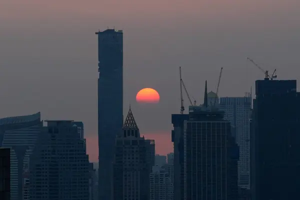 Bangkok gökdelenleri ve vinçlerle, Tayland 'da dramatik bir günbatımı sırasında ufuk çizgisi