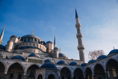 Haşmetli Sultan Ahmed Camii 'nin etkileyici kubbeleri ve minareleri İstanbul, Türkiye' deki canlı mavi gökyüzünün zemininde dimdik duruyor.