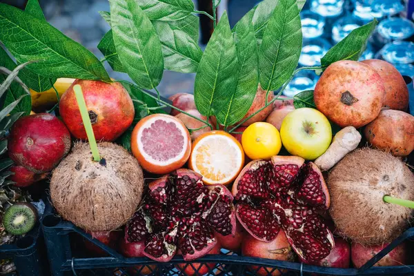 Nar, hindistan cevizi, turunçgil ve diğer egzotik meyvelerin canlı gösterisi, sağlıklı yeme, içecek, yaz meyveleri ve taze meyve suyunu teşvik eder.