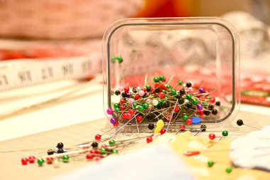 Çok renkli dikiş topları çalışma masasının üzerine saçılmış. Dikiş işleminin tam ortasında. El işi konsepti.