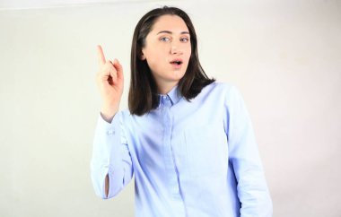 Mavi tişörtlü genç mavi gözlü bayan çok şaşırmış ve ilham almış görünüyor. Yeni fikir kavramı.