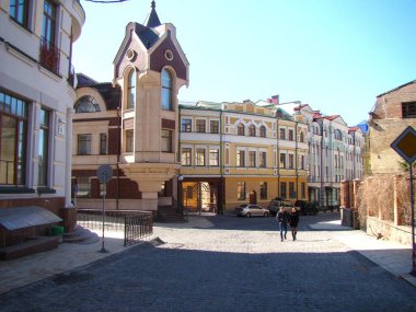 Nice street view of a typical European city on a sunny spring day.  Lovely couple walks towards the camera. clipart