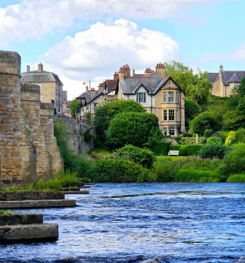Corbridge, Northumberland, Birleşik Krallık... 07.28.2024. Sıcak bir yaz gününde, nehrin üzerindeki küçük bir İngiliz köyünün çarpıcı manzarası. Yaşam tarzı kavramı 