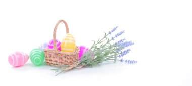 İnternet sitesi afişi, sosyal medya paylaşımı, poster, Paskalya kartı için klasik Paskalya teması. Bir sepet dolusu parlak rengarenk Paskalya yumurtası ve çiçek saf beyaz arka planda.