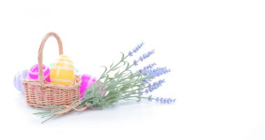 İnternet sitesi afişi, sosyal medya paylaşımı, poster, Paskalya kartı için klasik Paskalya teması. Bir sepet dolusu parlak rengarenk Paskalya yumurtası ve çiçek saf beyaz arka planda.