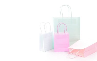 Beyaz arka planda pastel renklerde kağıt poşetler. Perakende kavramı.