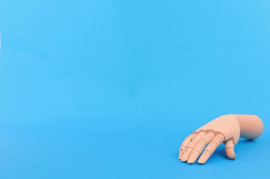 Saf mavi arkaplanda tahta bir el.