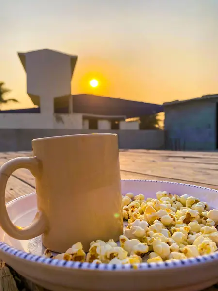 Gün batımının arka planında mısır olan bir fincan çay..