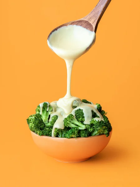 Pouring White Cheddar Sauce Cooked Broccoli Minimalist Orange Background Bowl — Stock Photo, Image