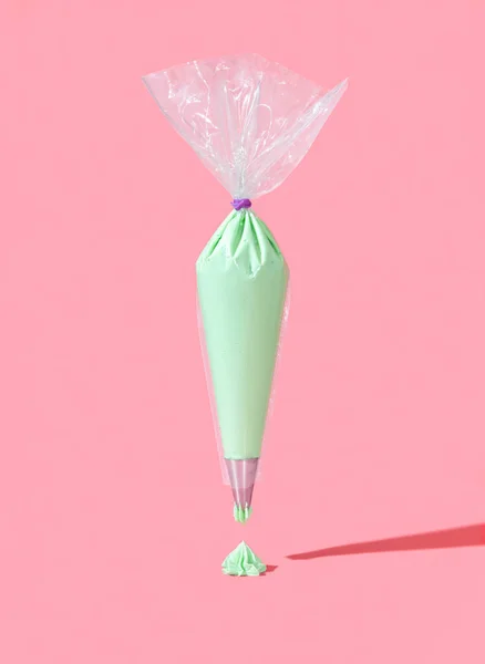 Bakverk Väska Full Grön Smörkräm Glasyr Minimalistisk Rosa Bakgrund Flygande — Stockfoto