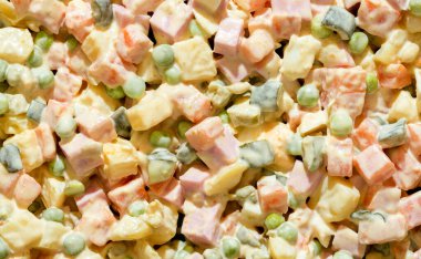 Olivier salatasıyla yakın çekim, yukarıdan manzara. Geleneksel bir Rus yemeği olan mayonez salatasıyla dolu arka plan..