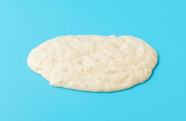 Ekşi ekmek başlatıcı mavi masada, yüksek açılı. Sağlıklı pişirmenin ana bileşeni mayadır..