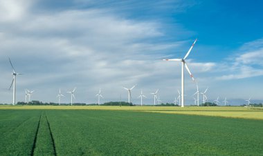 Almanya 'nın kuzeyinde Schleswig-Holstein eyâletinde, Kuzey Denizi kıyısında bir yel değirmeni parkı olan manzara. Güneşli bir günde yel değirmenleri ve tarım arazileri