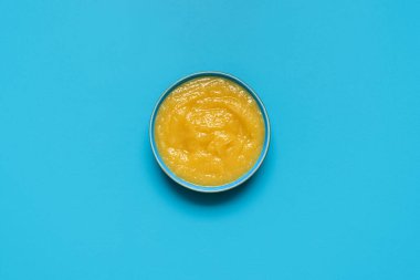 Mavi bir masada ev yapımı elma sosu minimalistiyle en iyi manzara.