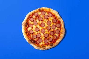 Mavi arka planda izole edilmiş ev yapımı pizza.