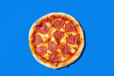 Yukarıda mavi arka planda izole edilmiş pizza salamı