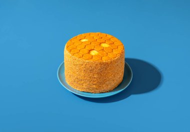 Medovik, bal katmanlı kek, mavi bir masada parlak ışık minimalisti.