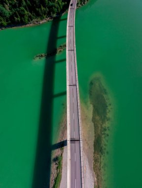 Sylvenstein Gölü üzerindeki köprünün havadan görünüşü, yazın güneşli bir gününde sabahın erken saatlerinde..