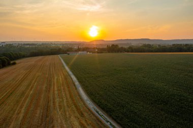 Almanya 'daki Schwabisch Malikanesi' nin hemen dışındaki tarım arazileriyle gün batımında insansız hava aracı görüntüsü.