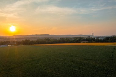 Almanya 'daki Schwabisch Malikanesi' nin hemen dışındaki tarım arazileriyle gün batımında insansız hava aracı görüntüsü.