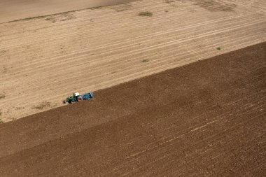 Almanya 'da Schwabisch Hall yakınlarındaki küçük bir köyde çalışan bir traktörün insansız hava görüntüsü.
