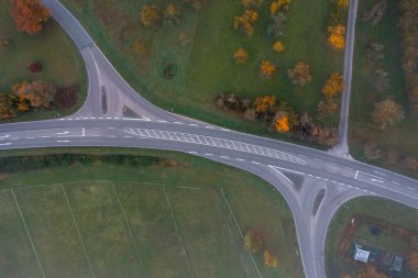 Sonbahar manzaralı bir yol kesişmesi, soğuk bir Ekim sabahında insansız hava aracı görüntüsü.