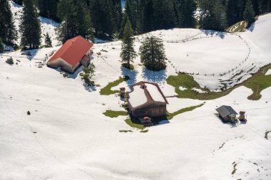 Karlı doğanın ortasında, Bavyera dağlarındaki Alman kulübesi, yüksek açı manzaralı.