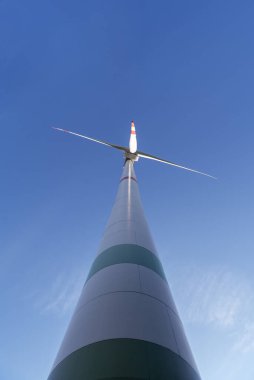 Almanya 'nın Baden Wurttemberg bölgesinde, mavi gökyüzünde izole edilmiş bir rüzgar türbini ile alçak açılı görüş