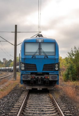 Yakıt depolama tankları taşıyan, Almanya 'da konuşlanmış bir elektrikli tren lokomotifinin ön görüntüsü.