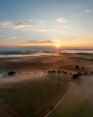 Sabahın altın saatinde Schwabisch Hall, Almanya 'da sisle kaplı tarımsal tarlalarla insansız hava aracı dikey manzarası