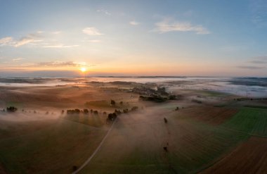 Sabahın altın saatinde Schwabisch Hall, Almanya 'da sisle kaplı tarımsal arazilerle insansız hava aracı panoraması.