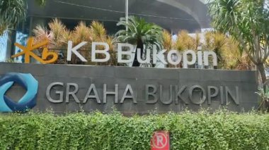 Surabaya, Endonezya - 3 Kasım 2024: Endonezya 'da KB Bukopin adlı orta sınıf özel bir banka binasının önünde. Bahçe süslemeleriyle duvarlarda sarmaşıklar