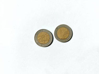 Artık işlemler için kullanılmayan eski 1000 rupiah sikkesi. Bozuk paranın dışı gümüş, içi altın, içi de yağ palmiyesi resmi. Beyaz bir arkaplanda