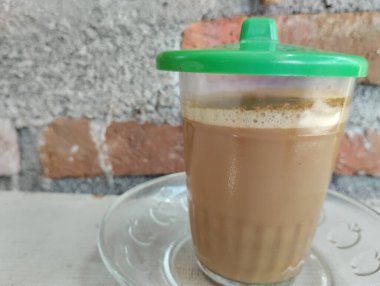 Luwak kahvesi hala yeşil cam kapaklı şeffaf bir bardakta sıcaktır.