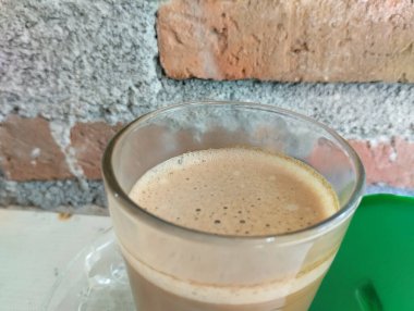 Luwak kahvesi hala yeşil cam kapaklı şeffaf bir bardakta sıcaktır.