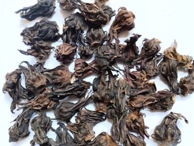 Arka planda kurumuş Roselle çiçekleri var. Kurumuş roselle çiçekleri gribi önlemek, ateş kaynaklı rahatsızlığı tedavi etmek ve antienflamatuar ve antibakteriyel özelliklere sahip olmak için faydalıdır..