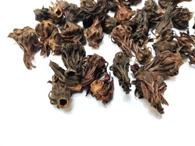Arka planda kurumuş Roselle çiçekleri var. Kurumuş roselle çiçekleri gribi önlemek, ateş kaynaklı rahatsızlığı tedavi etmek ve antienflamatuar ve antibakteriyel özelliklere sahip olmak için faydalıdır..