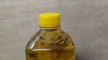 Palmiye yağı bazlı plastik şişelerde pişirme yağı ve ahşap doku arka planı