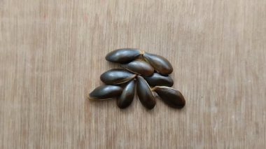 Sapodilla tohumları siyah ve ahşap arkaplanlıdır.
