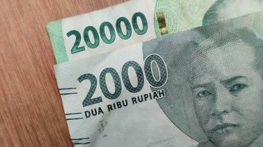 Ahşap bir arka planda iki bin rupiah ve yirmi bin rupiah. Endonezya para birimi (IDR). ekonomik kavram