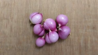 Ahşap arka planda kırmızı soğan. Kırmızı soğan, kalbin bakımı, kan şekerinin azaltılması ve kanserin önlenmesi gibi sağlık için çok yararlıdır..