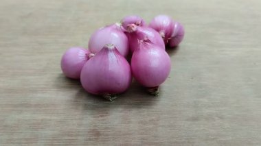 Ahşap arka planda kırmızı soğan. Kırmızı soğan, kalbin bakımı, kan şekerinin azaltılması ve kanserin önlenmesi gibi sağlık için çok yararlıdır..